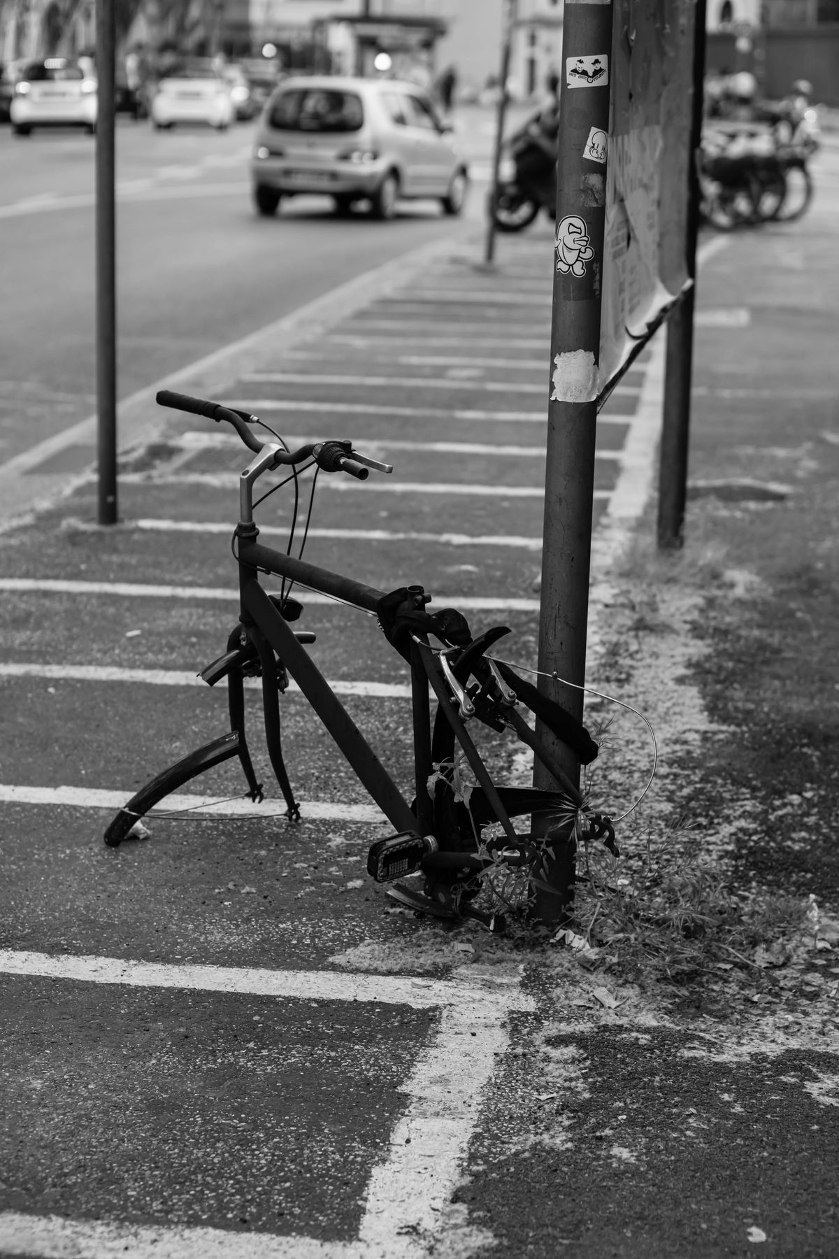 Hylätyn näköinen rikkinäinen polkupyörä kadulla, mustavalkokuva